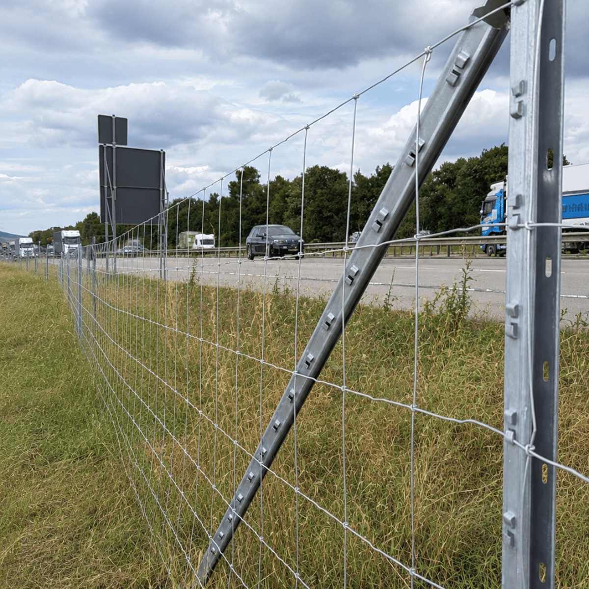 Knotengeflechtzaun mit abgestütztem Pfahl entlang einer Straße